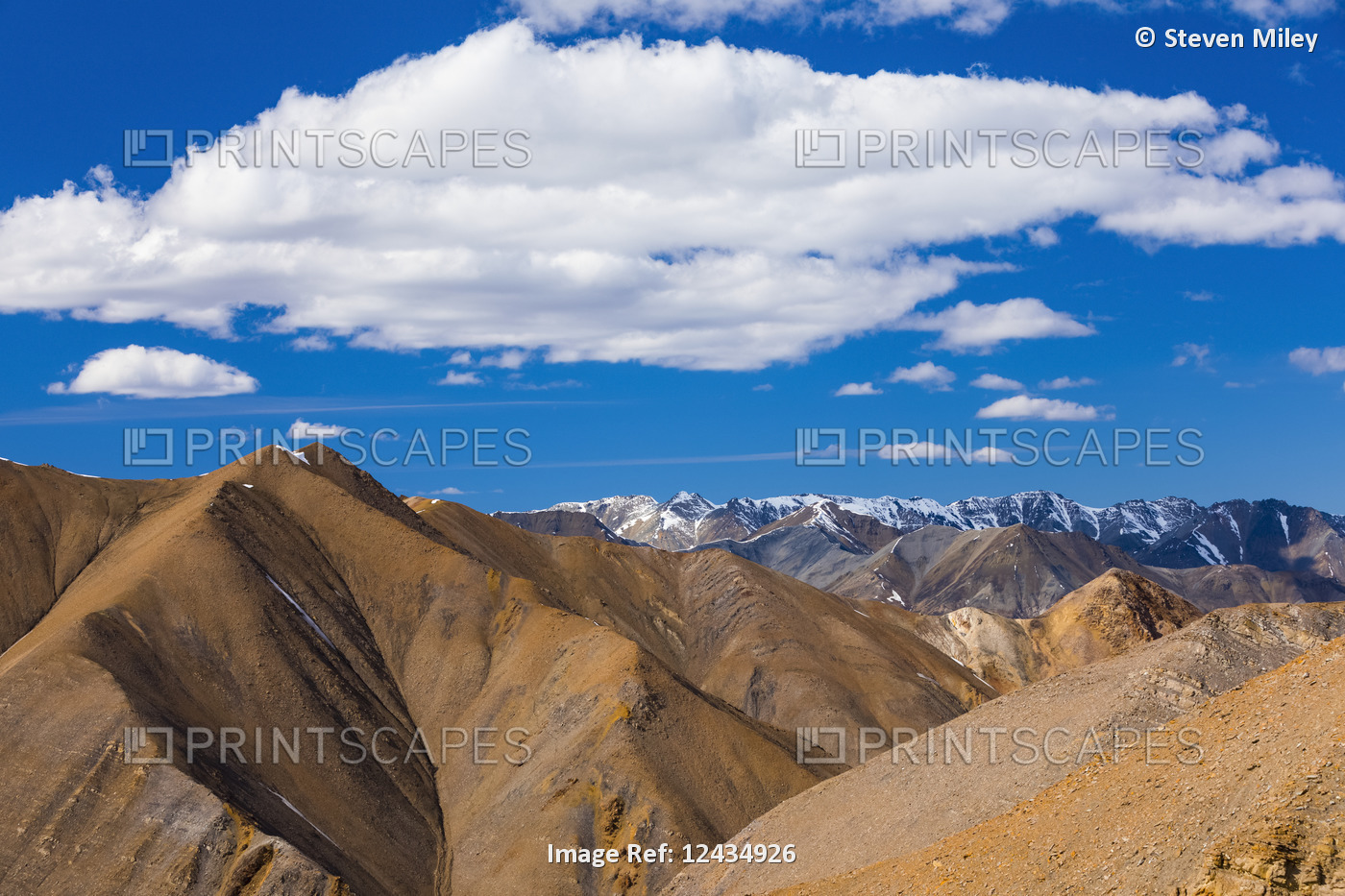 Clouds hover over endless bare, rugged mountain ridges in the Polychrome ...