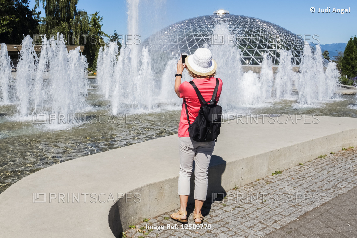 A female tourist takes a photo at Queen Elizabeth Park; Vancouver, British ...