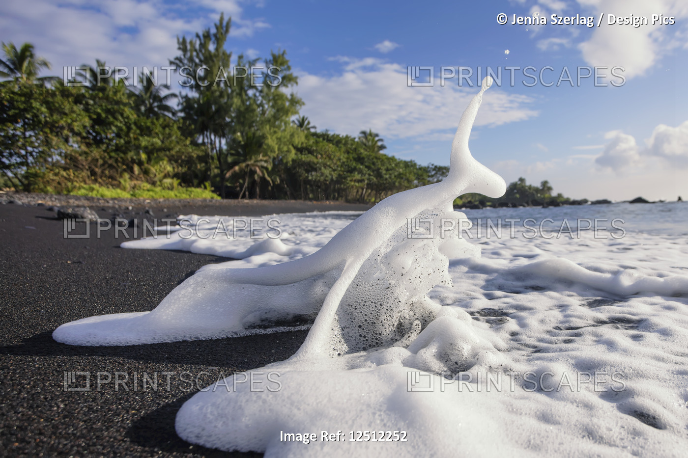 Sea foam splashing on the shore on Hana's black sand beach; Hana, Maui, Hawaii, ...
