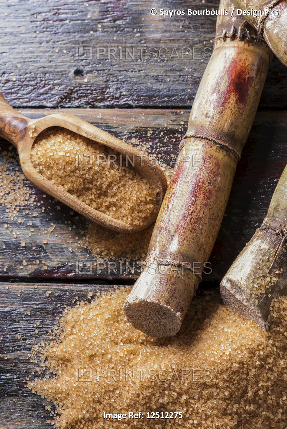 Raw sugar cane on a wooden surface and in a wooden scoop