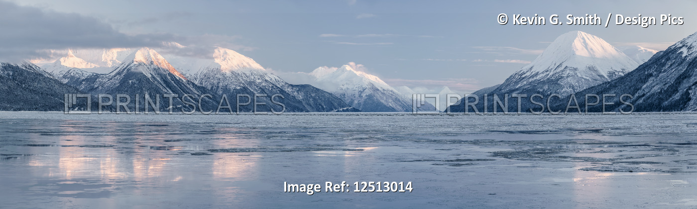 Sunset lights up the snow-covered peaks of the Chugach Mountains along ...