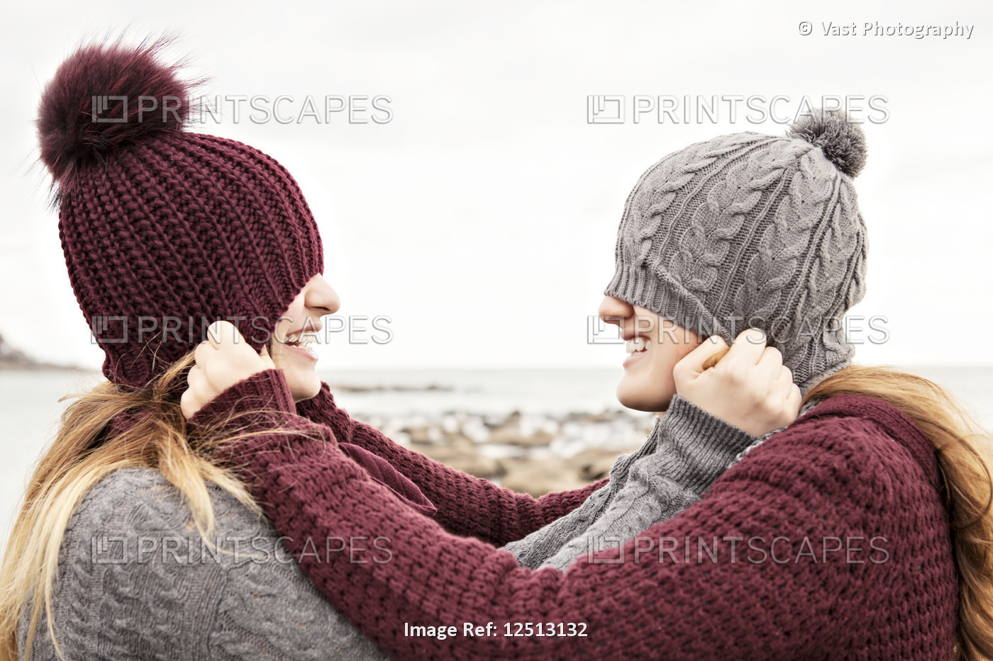 Two friends playing on the beach wearing knit hats and scarves, Woodbine Beach; ...