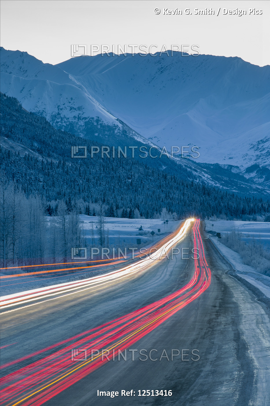 Car lights are blurred down the Seward Highway at dusk in winter, Turnagain ...