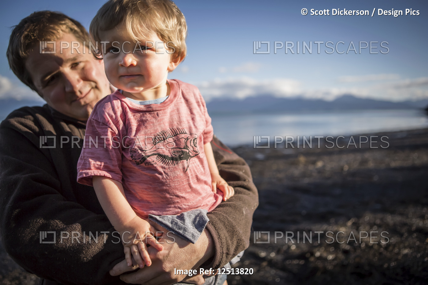 Father holds young toddler at sunset along the Homer beach, South-central ...
