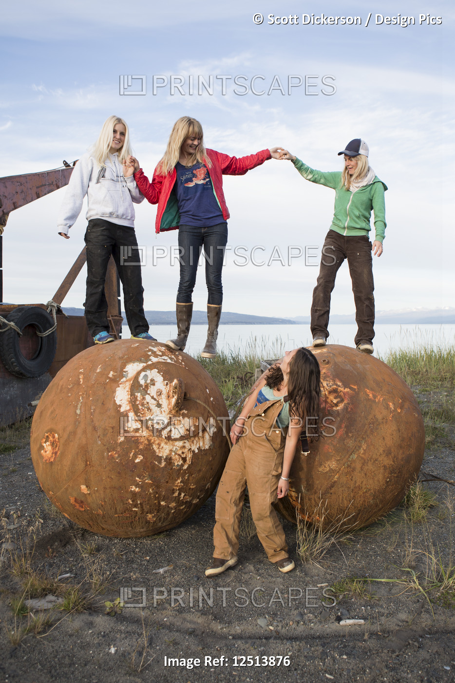 Group of friends hanging out among old commercial fishing artifacts, ...