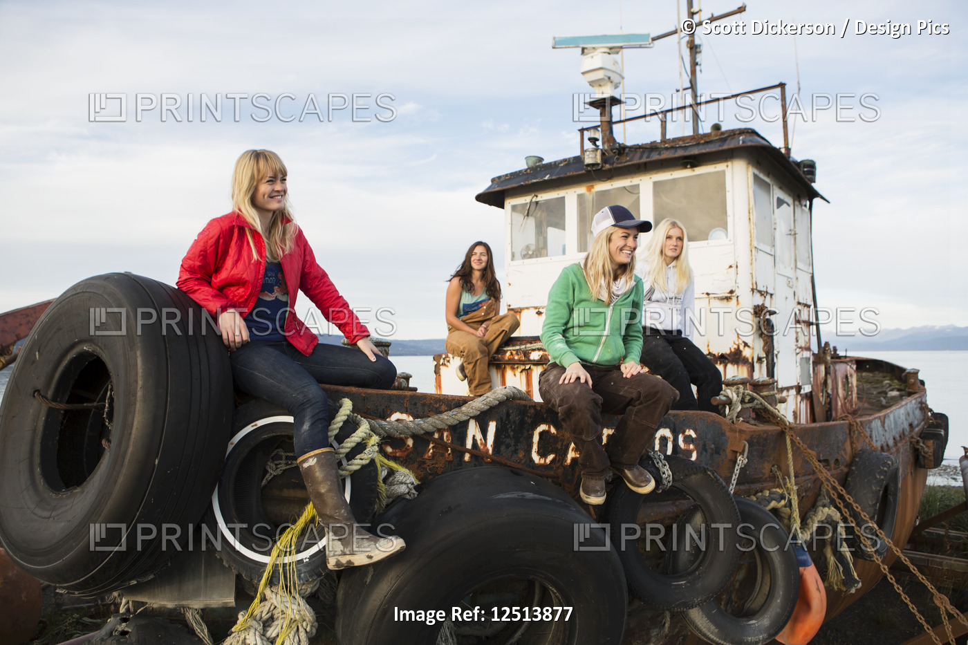 Group of friends hanging out on a dilapidated fishing boat along coastal ...