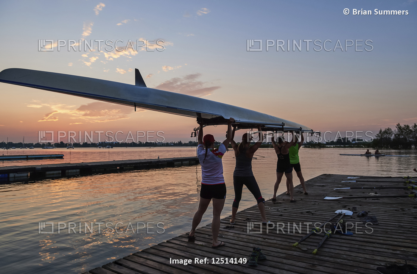 Women from the Hanlan Boat Club launching a rowing scull into Lake Ontario at ...