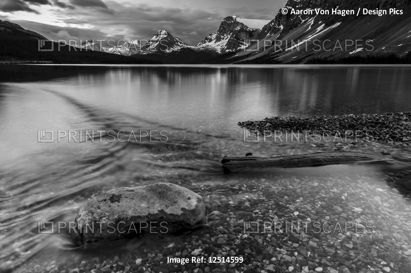 Tranquil, clear water along the shoreline of a lake in Banff National Park; ...