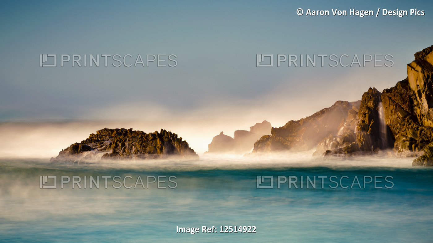 Mist over the turquoise water along the rugged coastline; Big Sur, California, ...
