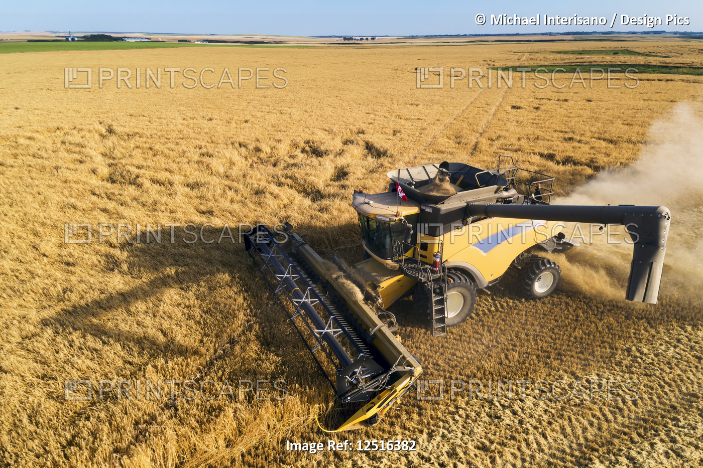 Aerial view of a combine at harvest in a barley field; Beiseker, Alberta, Canada