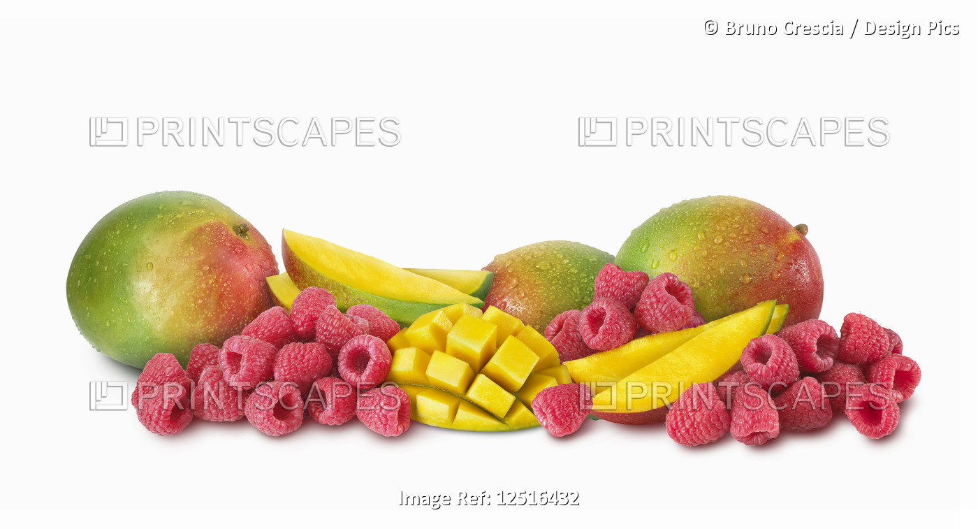 Fresh raspberries and mangoes on a white background