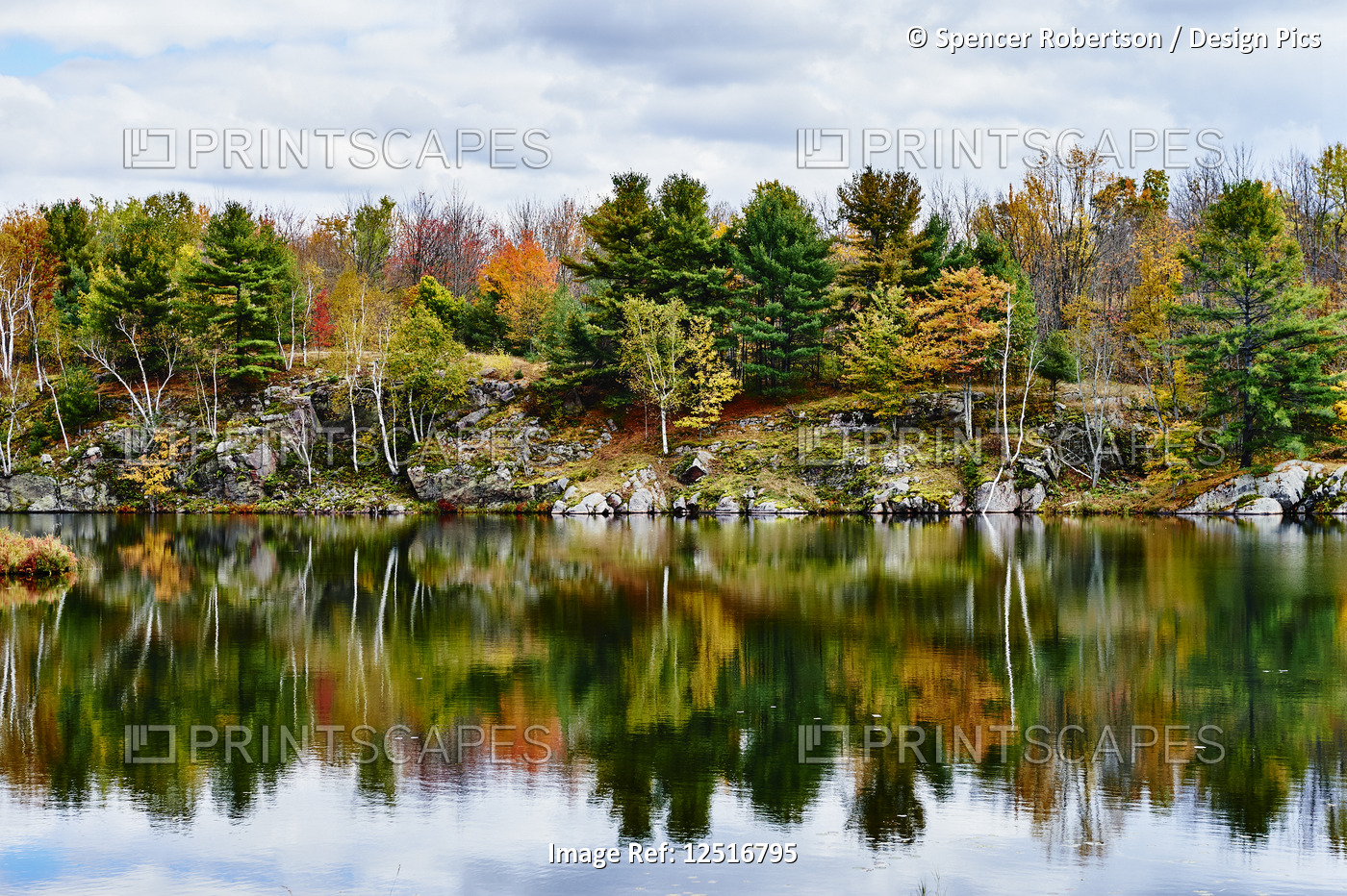 Autumn coloured foliage and clouds in Frontenac Provincial Park reflected in ...