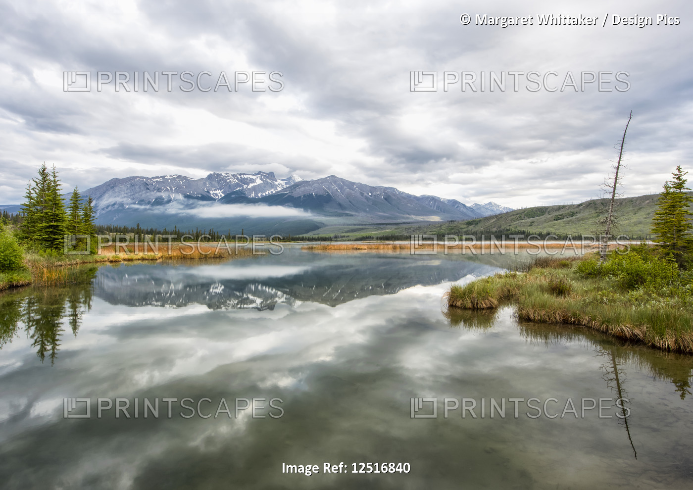 Lake reflections and the Rocky Mountains near Jasper in the early morning, ...