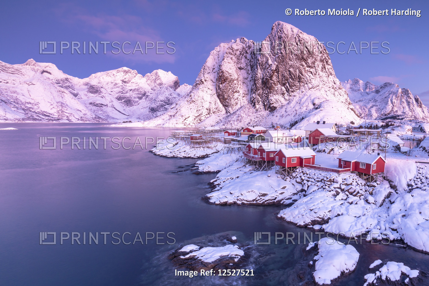 Pink sunrise on snowy peaks surrounded by the frozen sea around the village of Hamnoy, Nordland, Lof