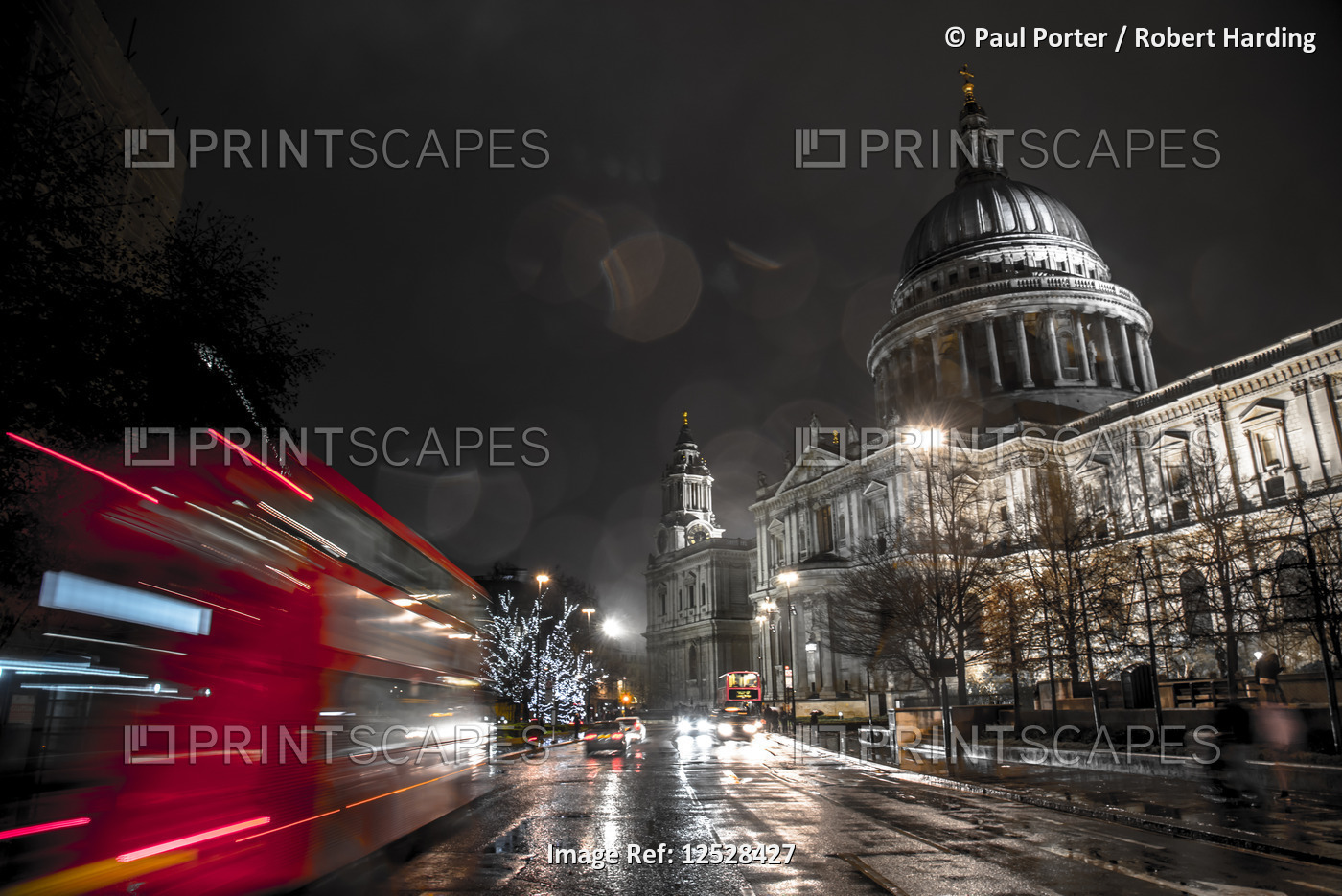 A London bus drives past St. Paul's Cathedral towards Christmas lights, London, England, United King