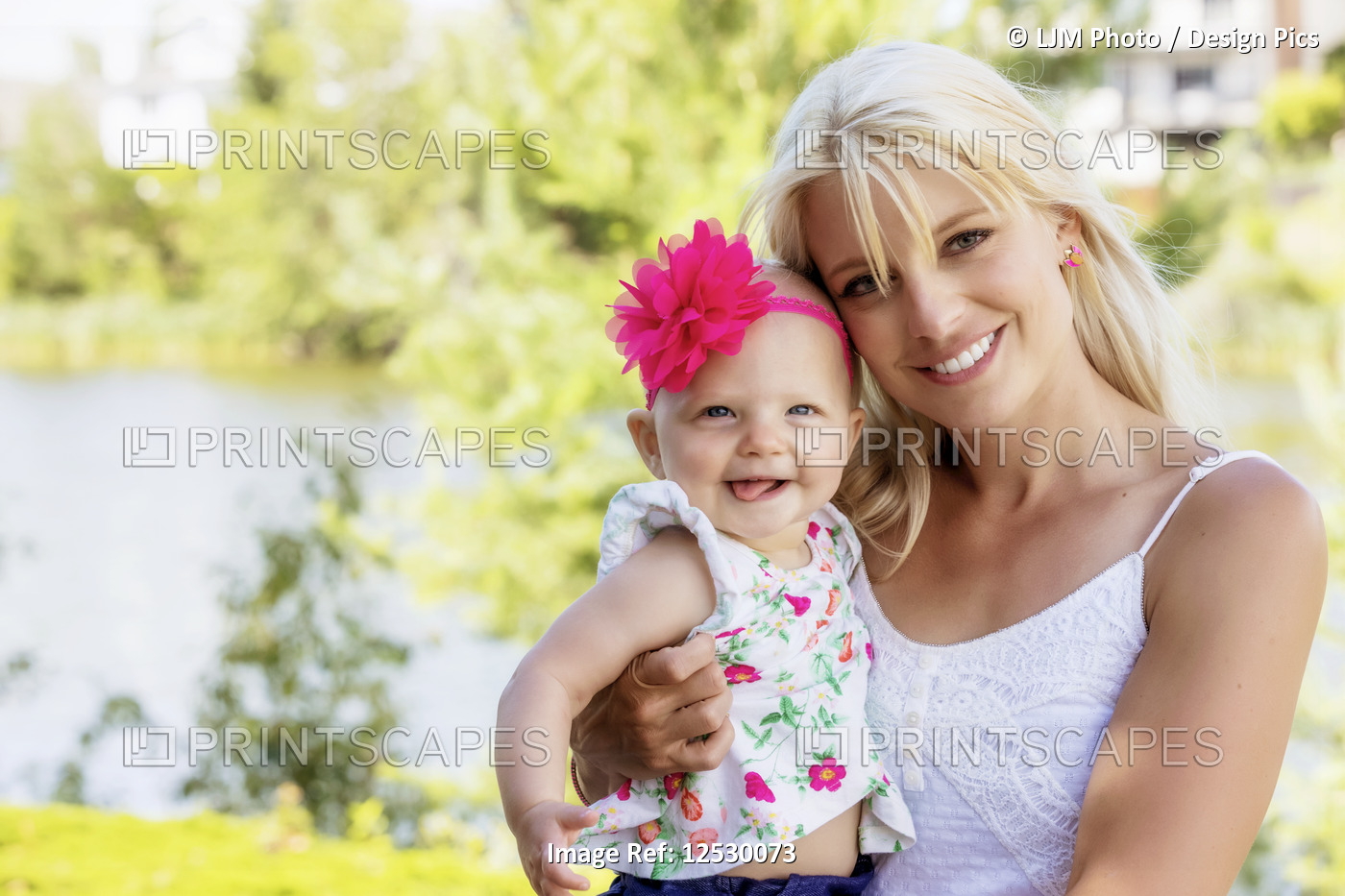 A beautiful young mother with long blonde hair enjoying quality time with her ...