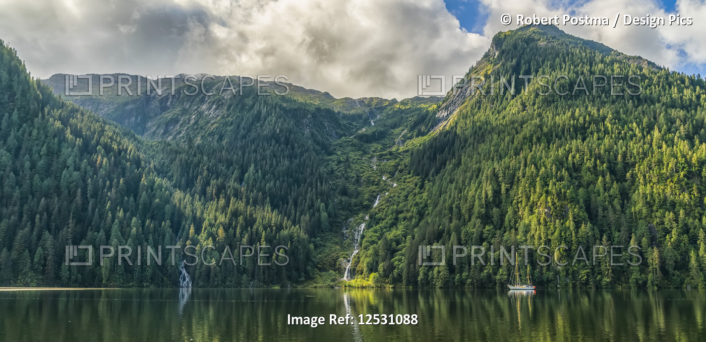 Scenic view of the Great Bear Rainforest area with a sailboat on the water; ...
