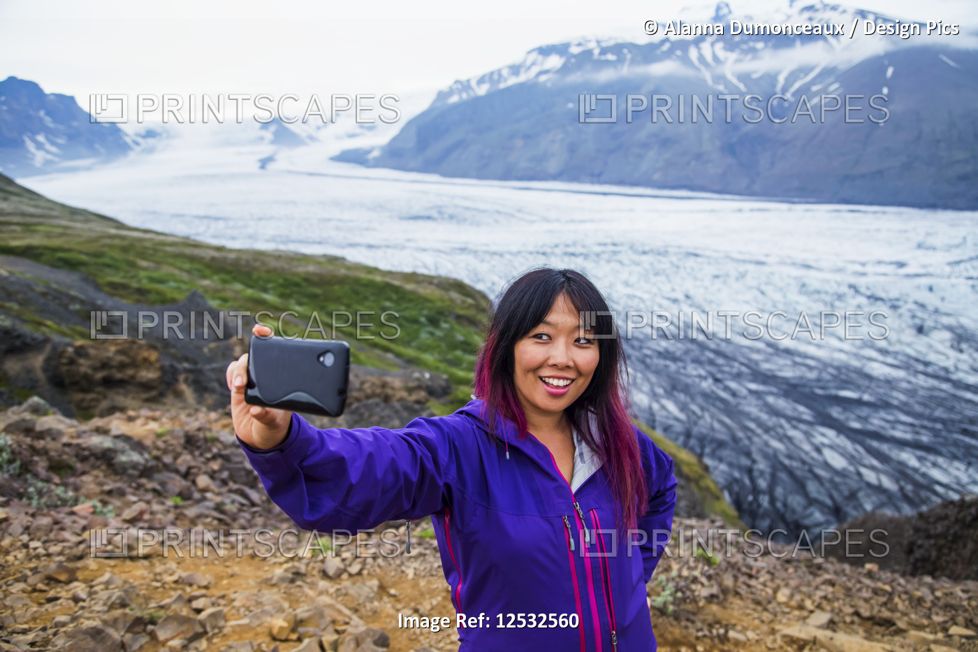 An asian female hiker takes a self-portrait from the mountain top with the ...
