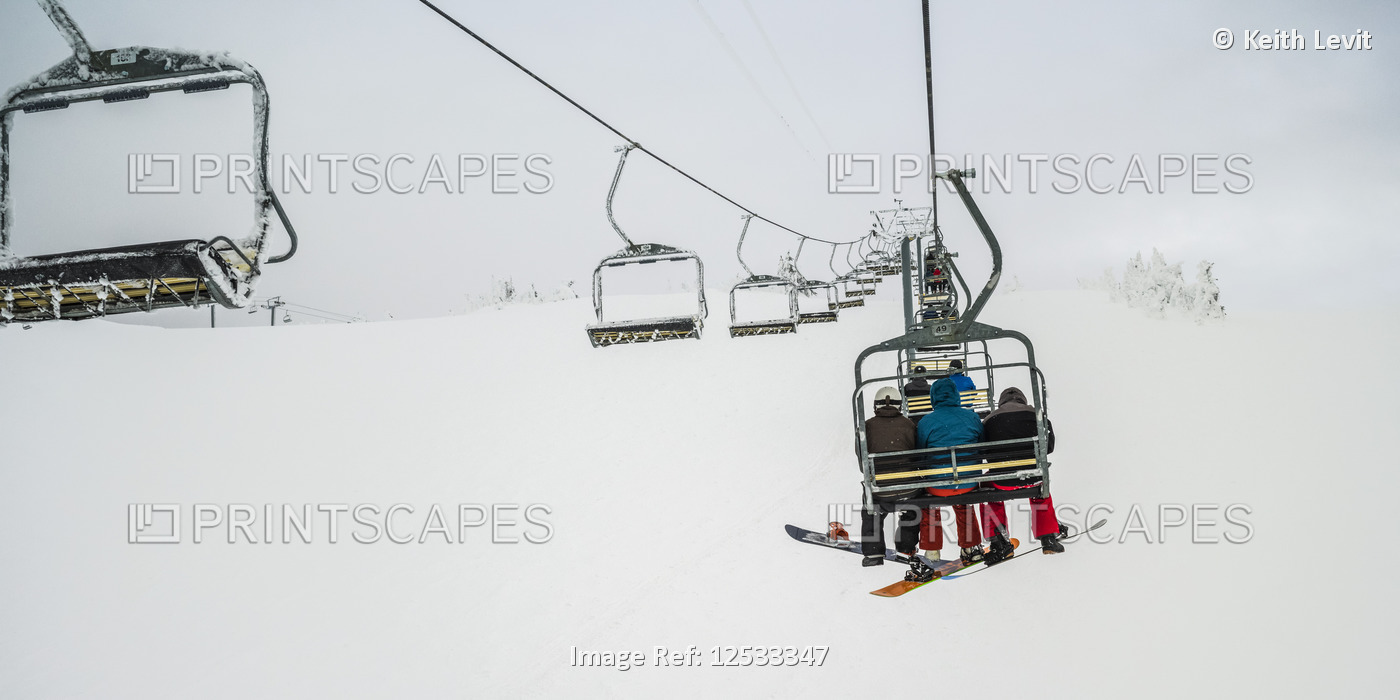 Skiers on a chairlift at Sun Peaks ski resort; Kamloops, British Columbia, ...