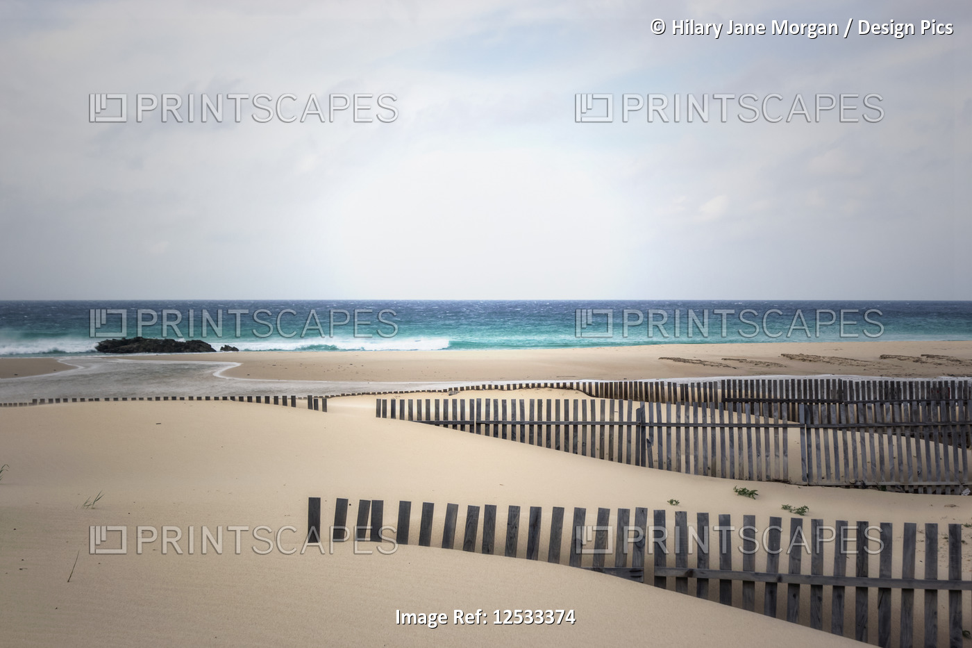 Wooden fencing on windswept beach and atlantic ocean; Tarifa, Cadiz Province, ...