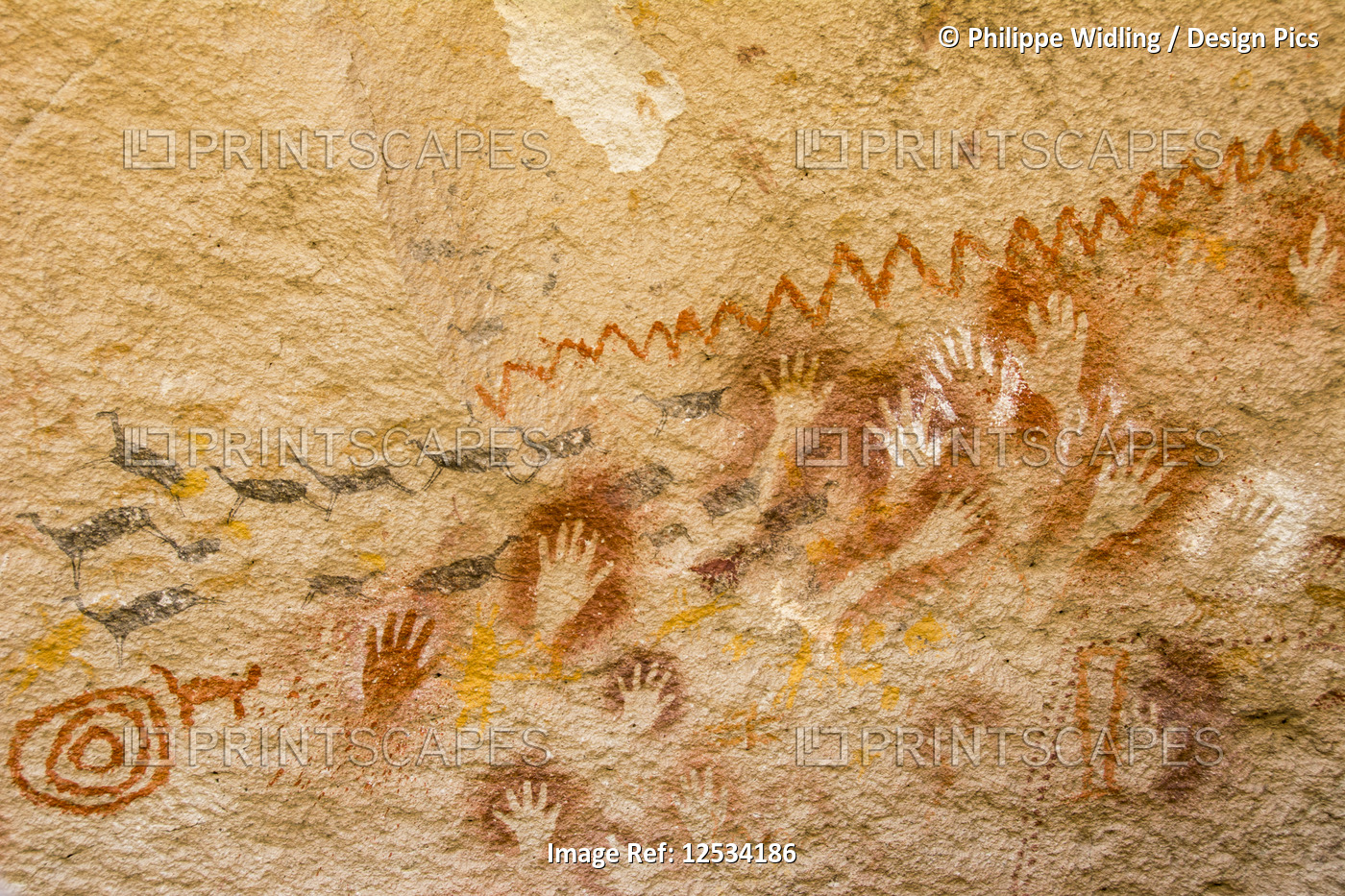 Colourful pictograms and handprints on a rock face; Santa Cruz, Argentina