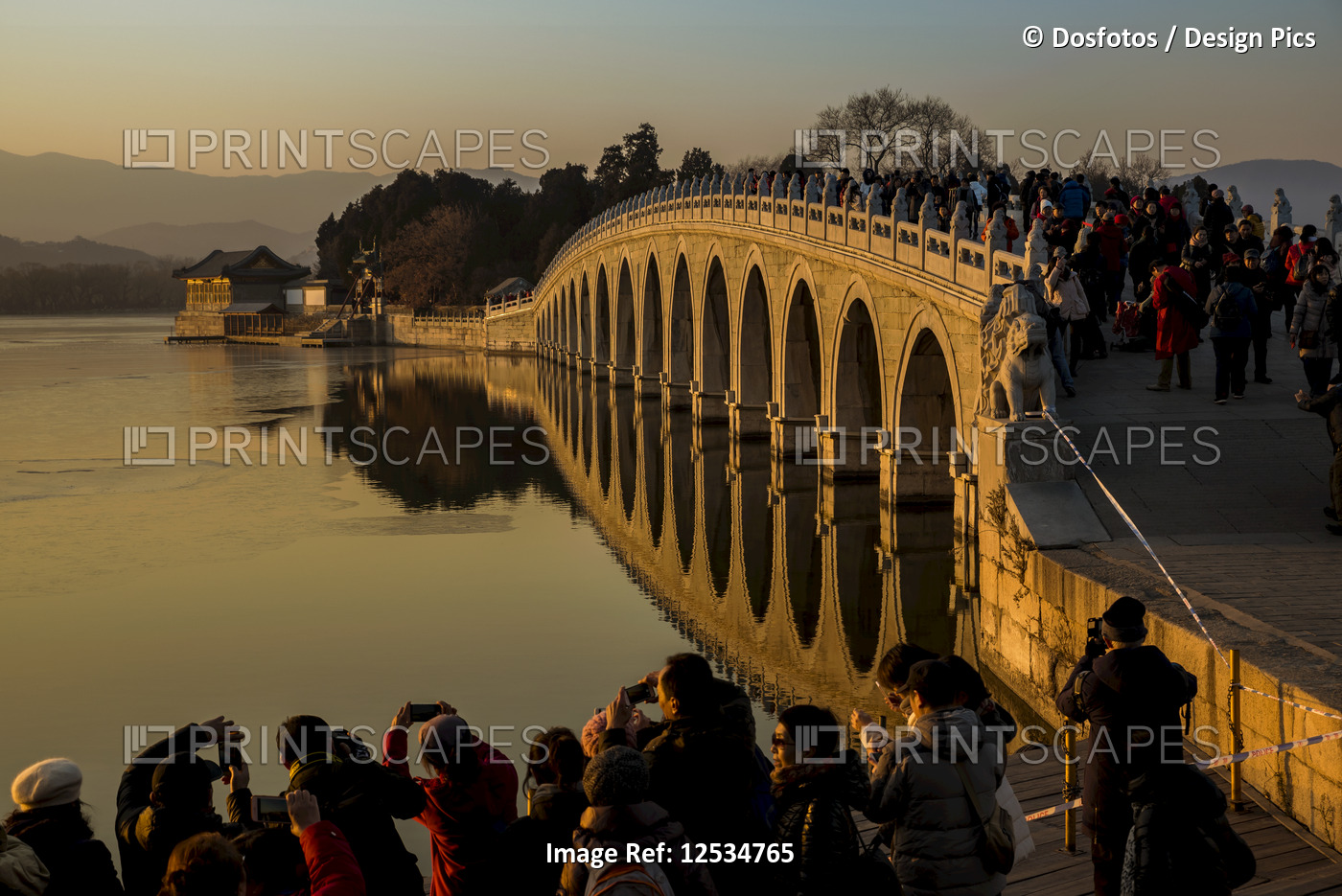 Crowd of tourists taking photographs of the 17 Arch Bridge at sunset, The ...