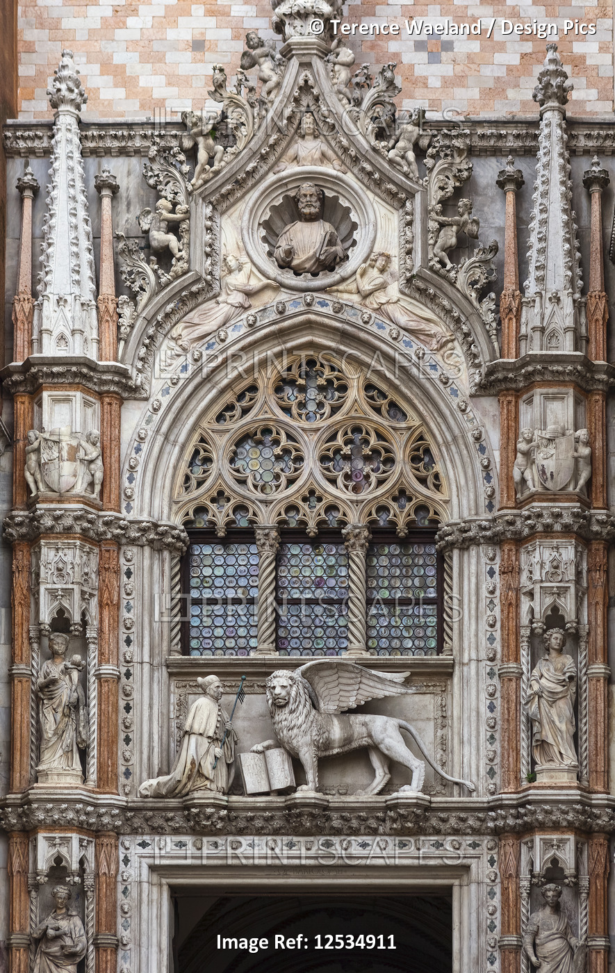 Statue of Doge and winged lion, symbol of Saint Mark, above doorway entrance to ...