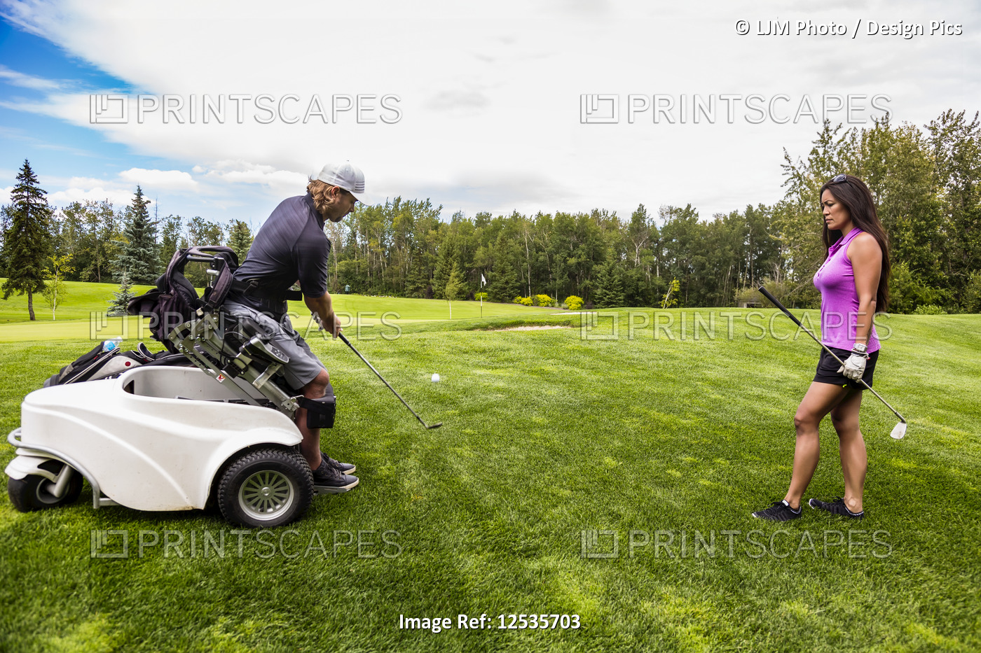 A physically disabled golfer, using a specialized wheelchair, hits the golf ...