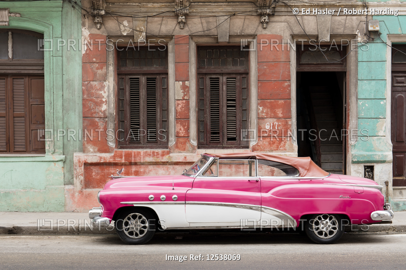 A pink and white vintage American convertible car, parked on a street in Havana, Cuba, West Indies, 