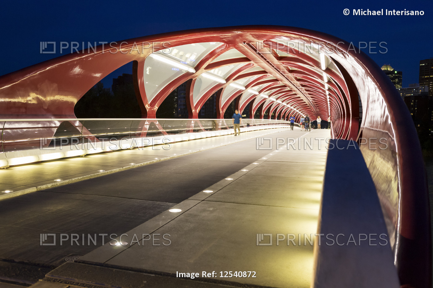 Glowing lights inside the Peace Bridge at night, a red steel pedestrian bridge ...