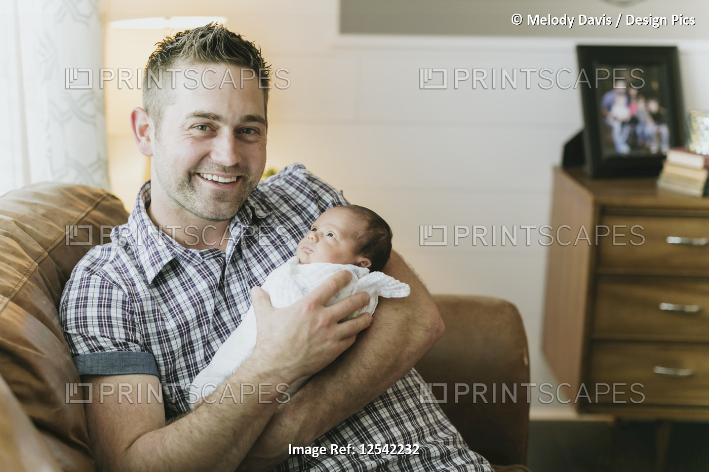 Portrait of a father holding his newborn baby; Surrey, British Columbia, Canada