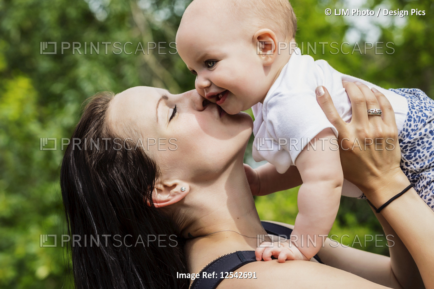 A young mother spending quality time with her daughter in a park during the ...