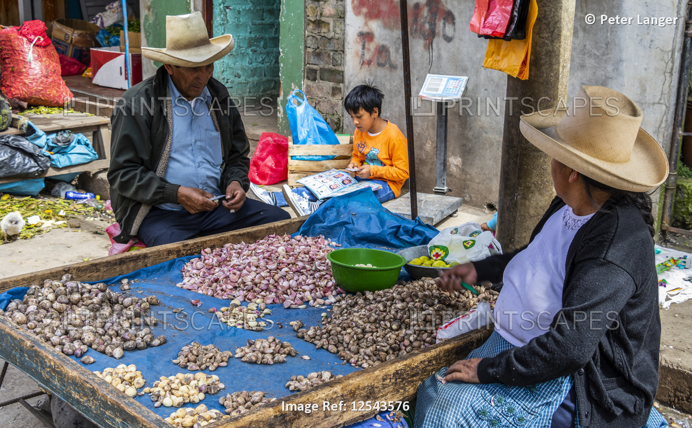 Couple peeling garlic at the market; Cajamarca, Peru