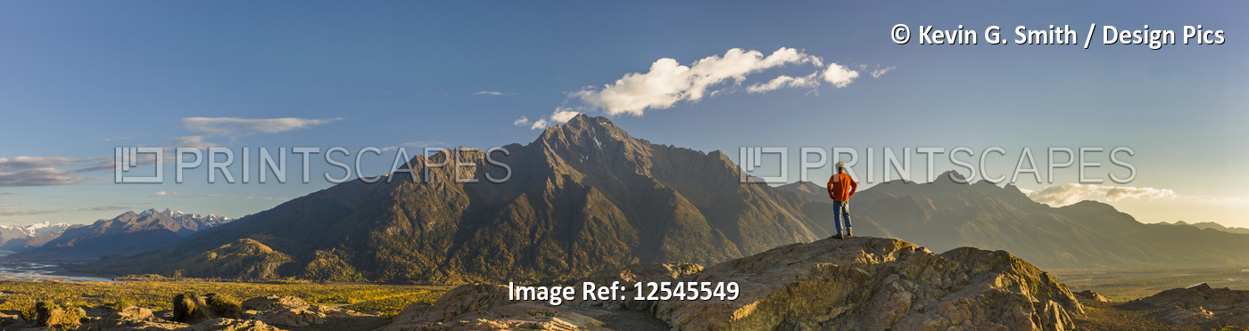 Panoramic view of a man standing atop the Butte, Pioneer Peak and the Knik ...
