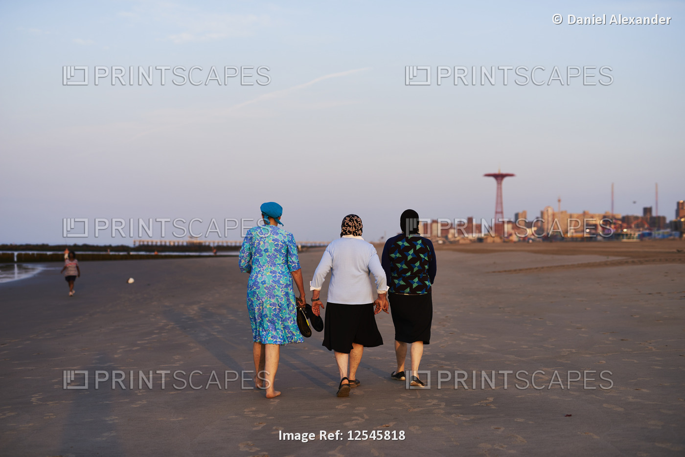 Orthodox Jewish women walking Coney Island beach after sunrise; Coney Island, ...