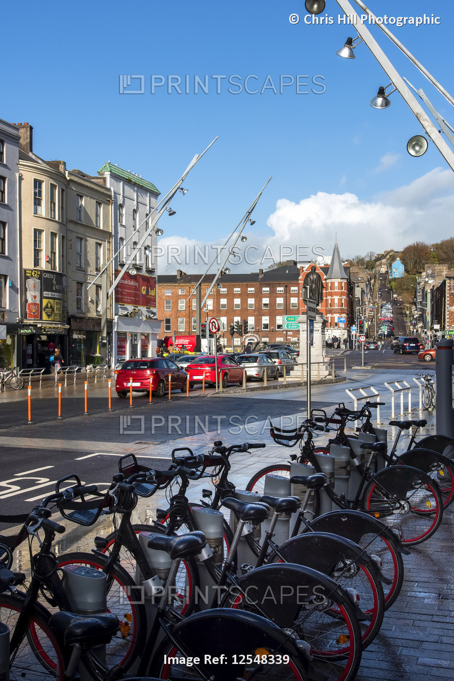 Bicycles for rent lined up in a rack along a street in the Cork City centre; ...