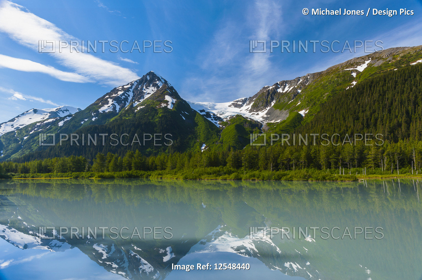 Explorer Glacier is seen reflecting in the calm silty waters of Explorer Lake ...