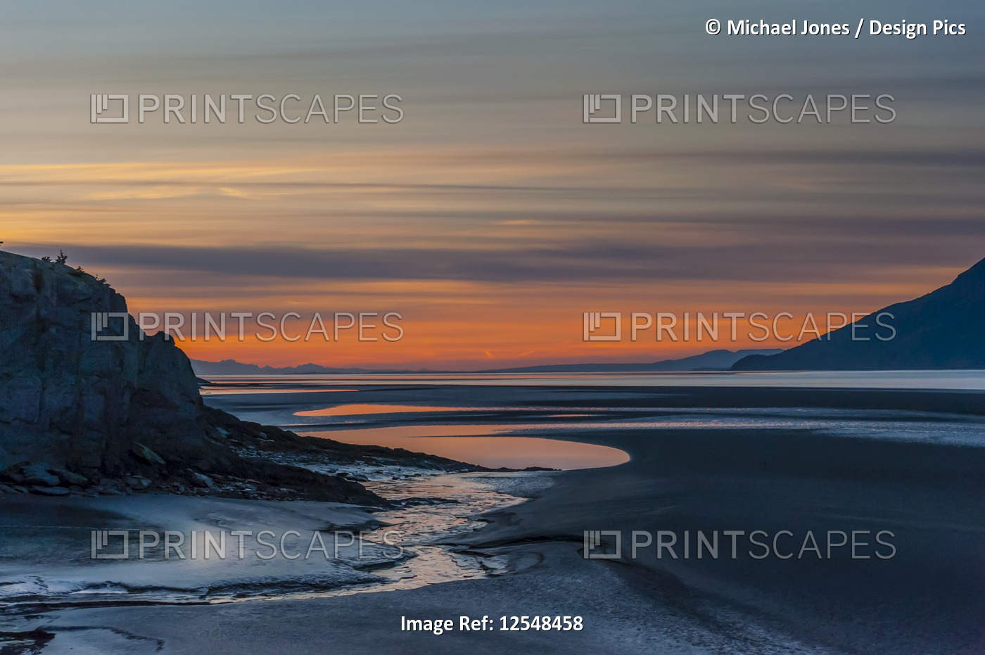 The setting sun over Alaska's Cook Inlet on a summer evening in South-central ...
