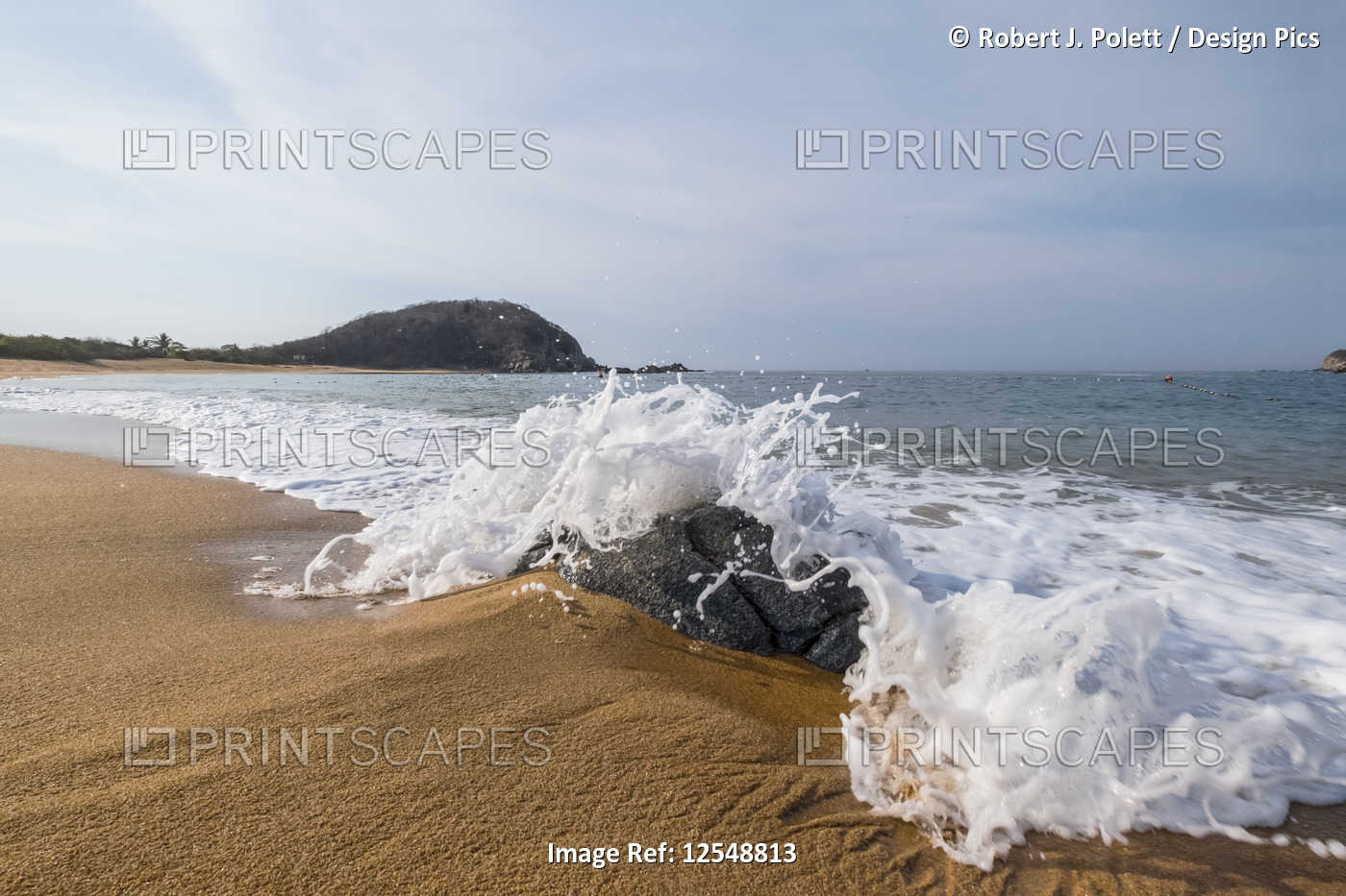 Waves washing up on a beach of golden sand; Huatulco, Oaxaca, Mexico