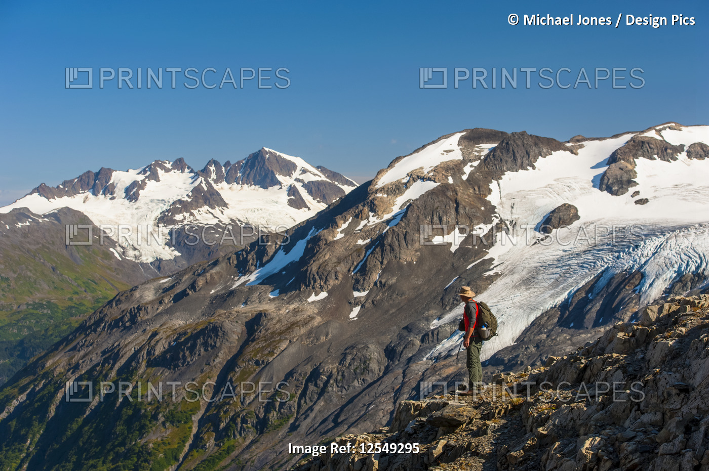 A man hiking near the Harding Icefield Trail with the Kenai Mountains and an ...