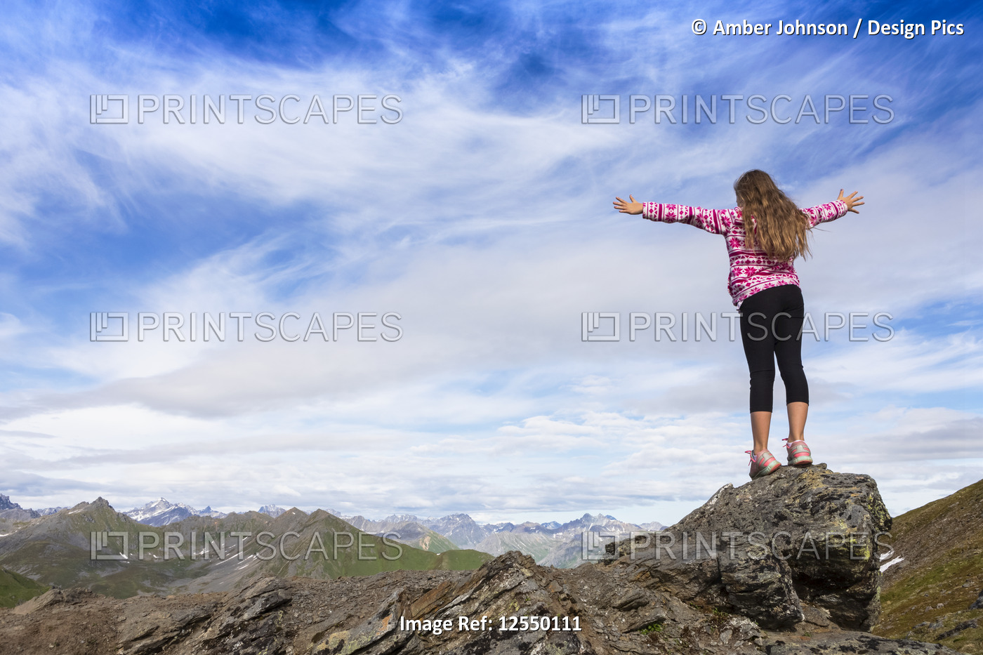 Pre-teen girl with hands in the air, enjoying the view of the Talkeetna ...