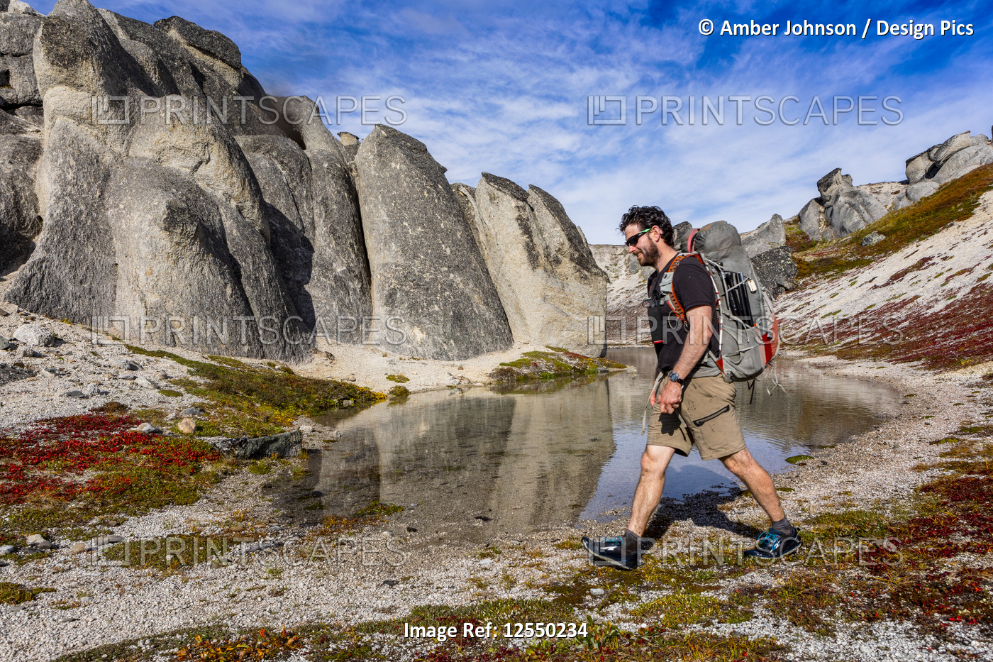 Man backpacking past pond and giant rocks on the Kesugi Ridge Trail, Denali ...