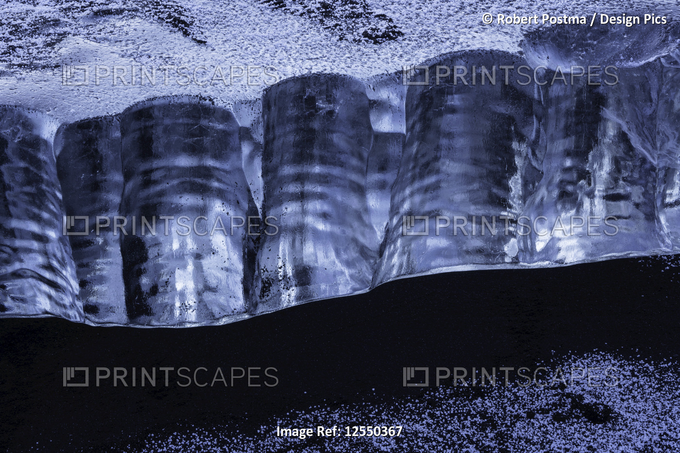 Close-up of a piece of ice sitting in the black sand on the South shore of ...
