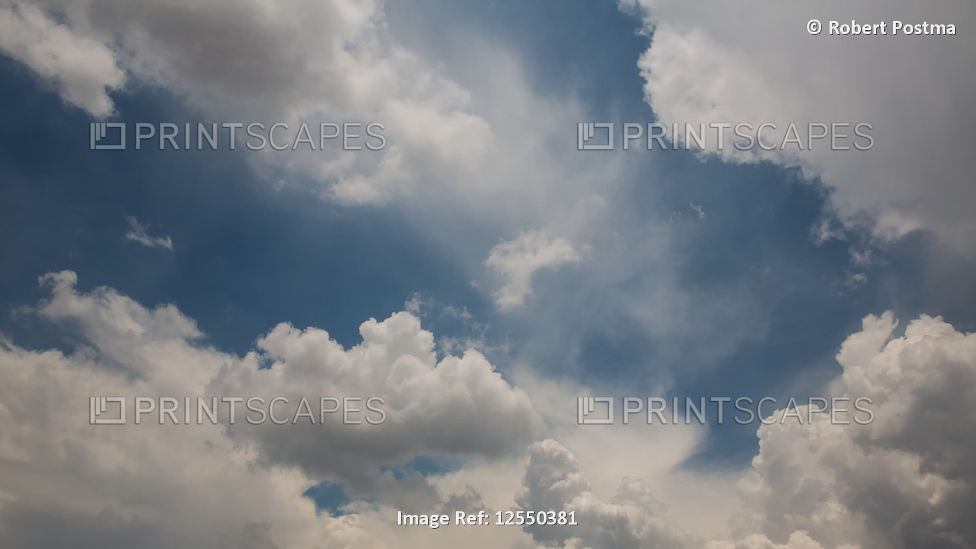 Clouds moving across a blue sky and gathering in a storm formation; Cochabamba, ...