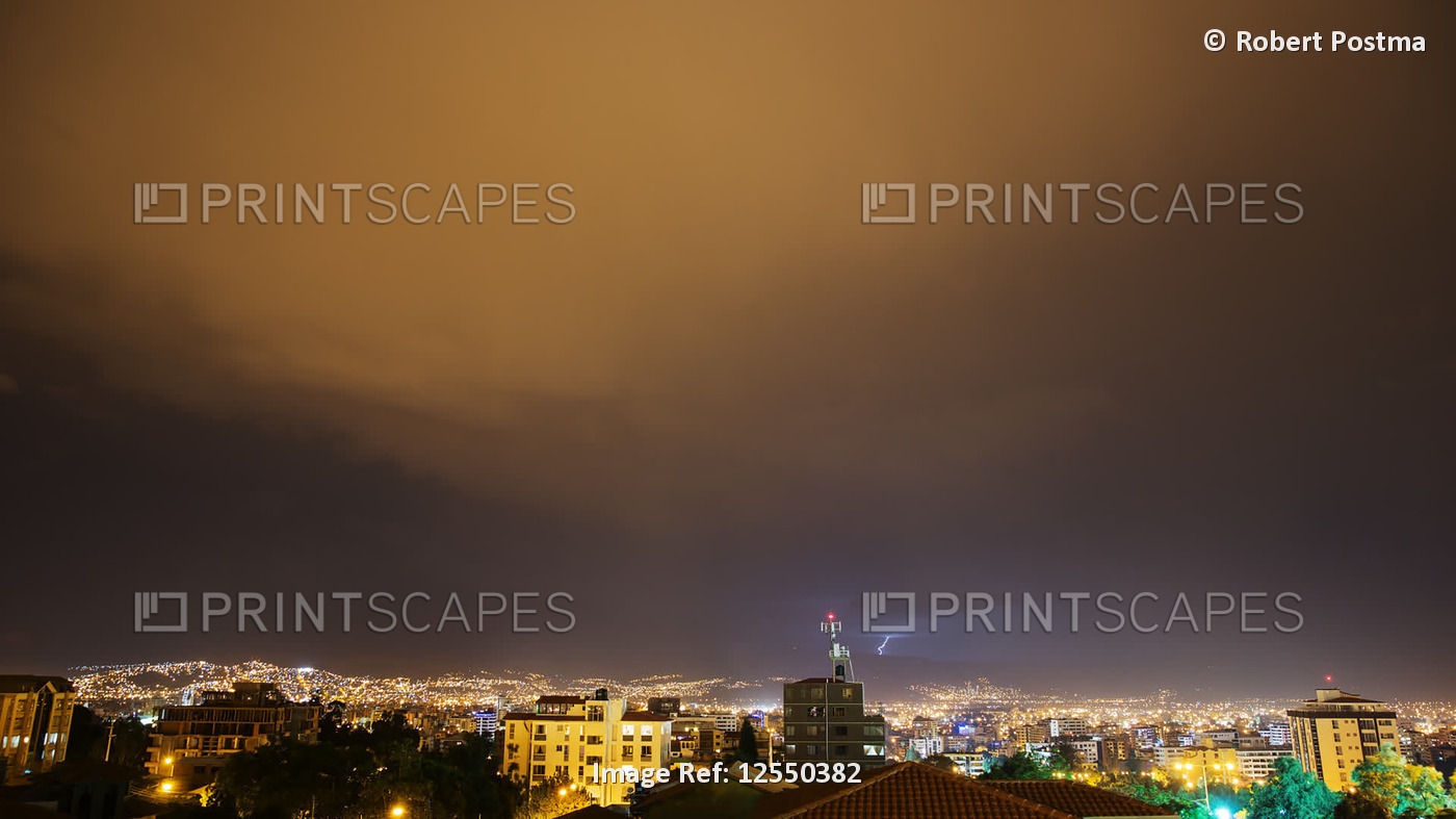 Lightning storm over an illuminated city at night; Cochabamba, Cercado ...