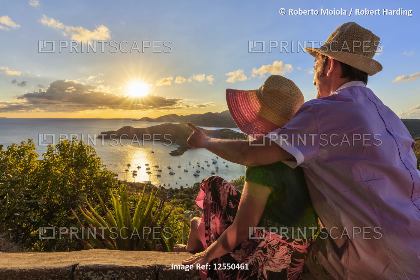 Couple look to the English Harbor from Shirley Heights at sunset, Antigua, Antigua and Barbuda, Leew