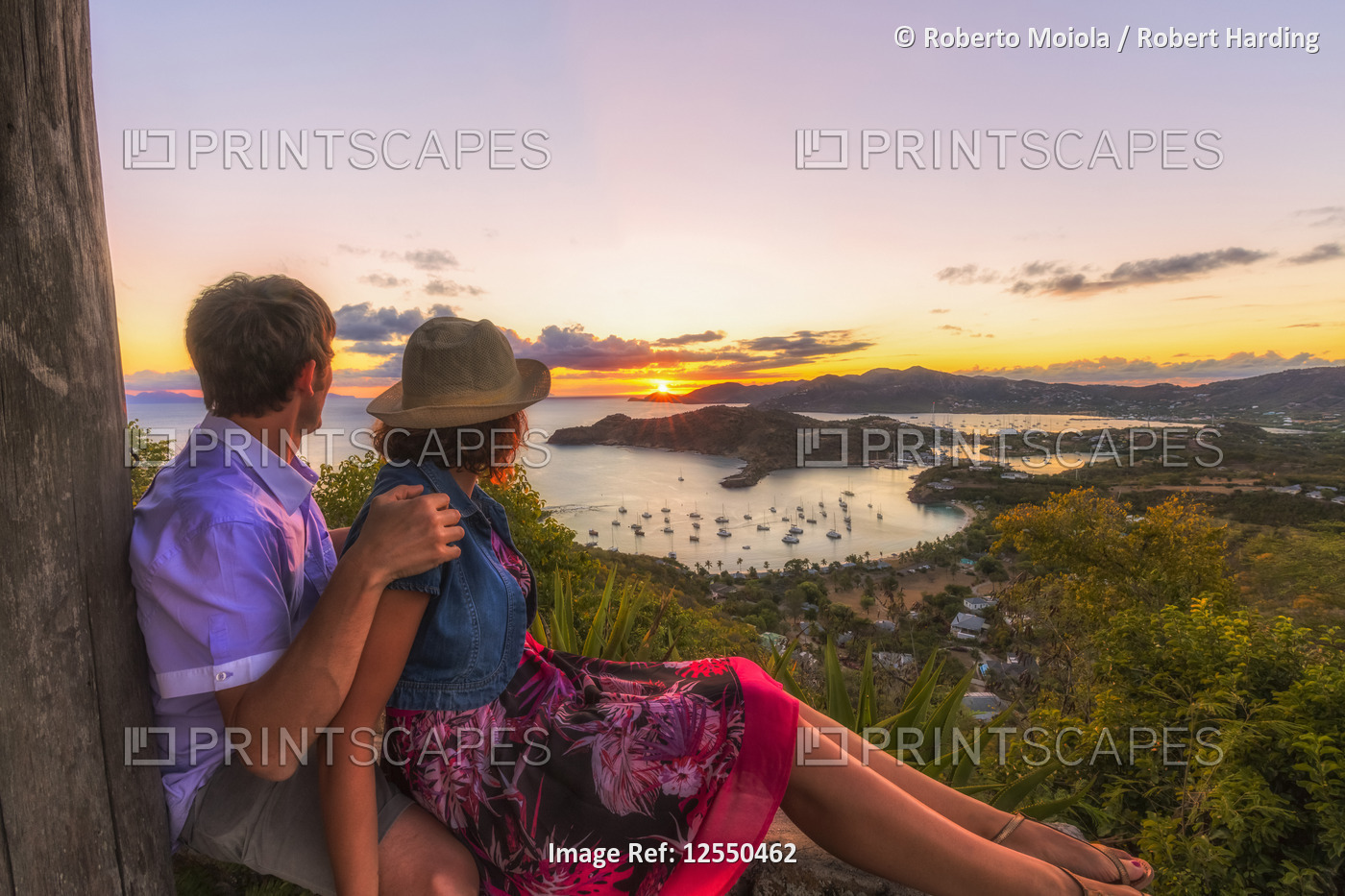 Couple look to the English Harbor from Shirley Heights at sunset, Antigua, Antigua and Barbuda, Leew