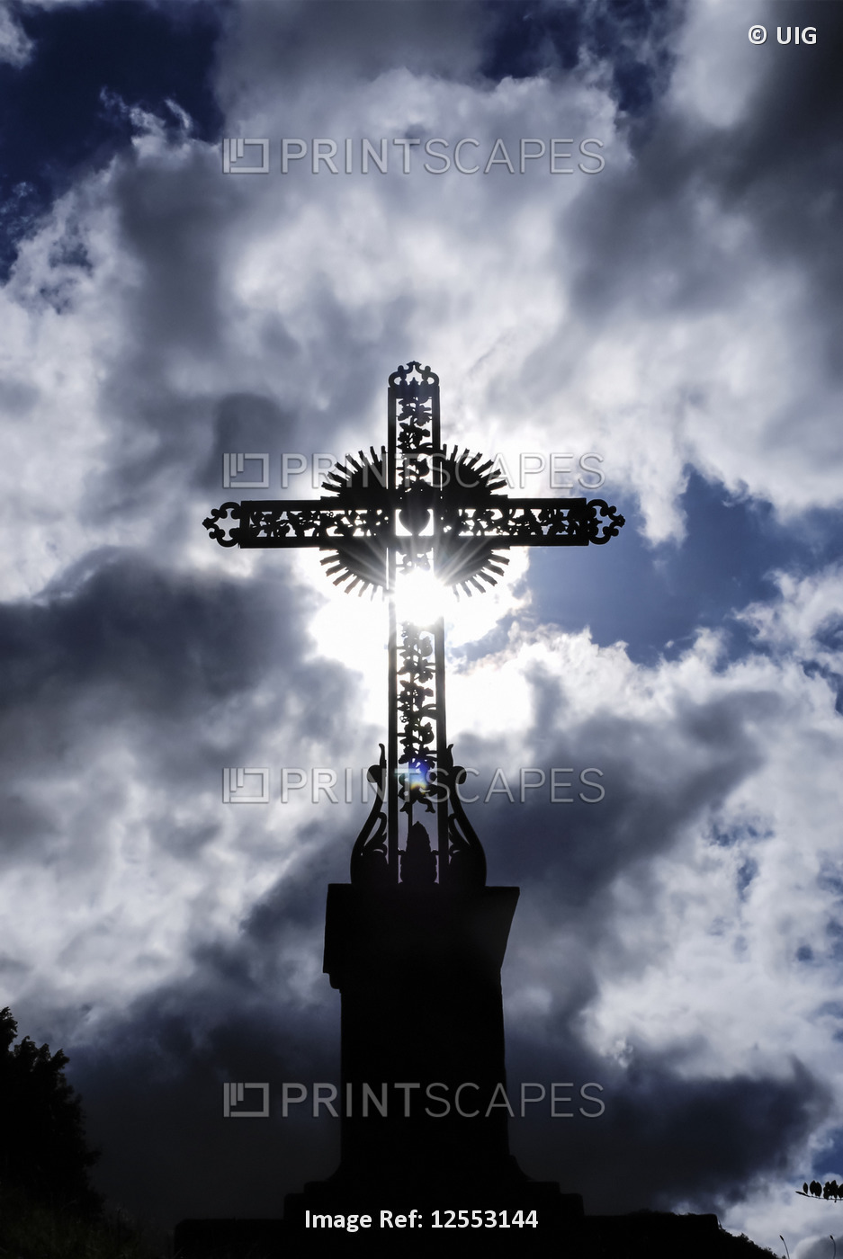 Backlit cross with glowing clouds and sunlight