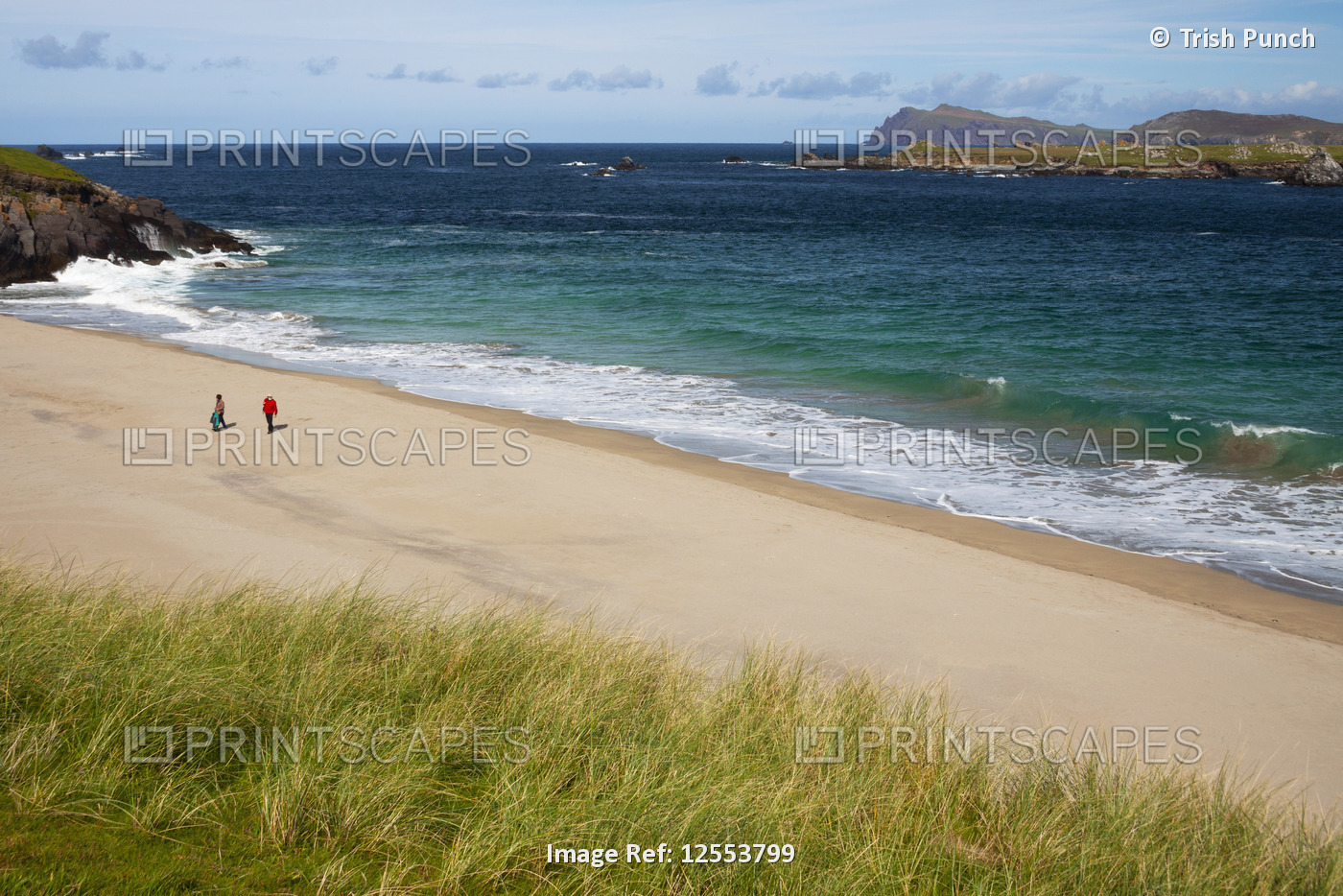Two people walk on the beach of Great Blasket Island on the Dingle Peninsula, ...