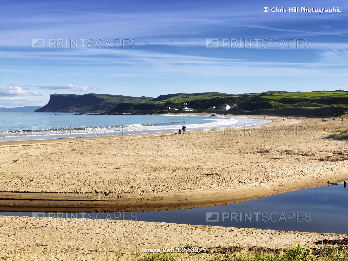 People enjoying the beach along the Atlantic coast with lush green landscape ...